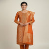 “Peach colored stitched women’s suit with traditional printed design and detailed neckline, neatly folded and displayed.”