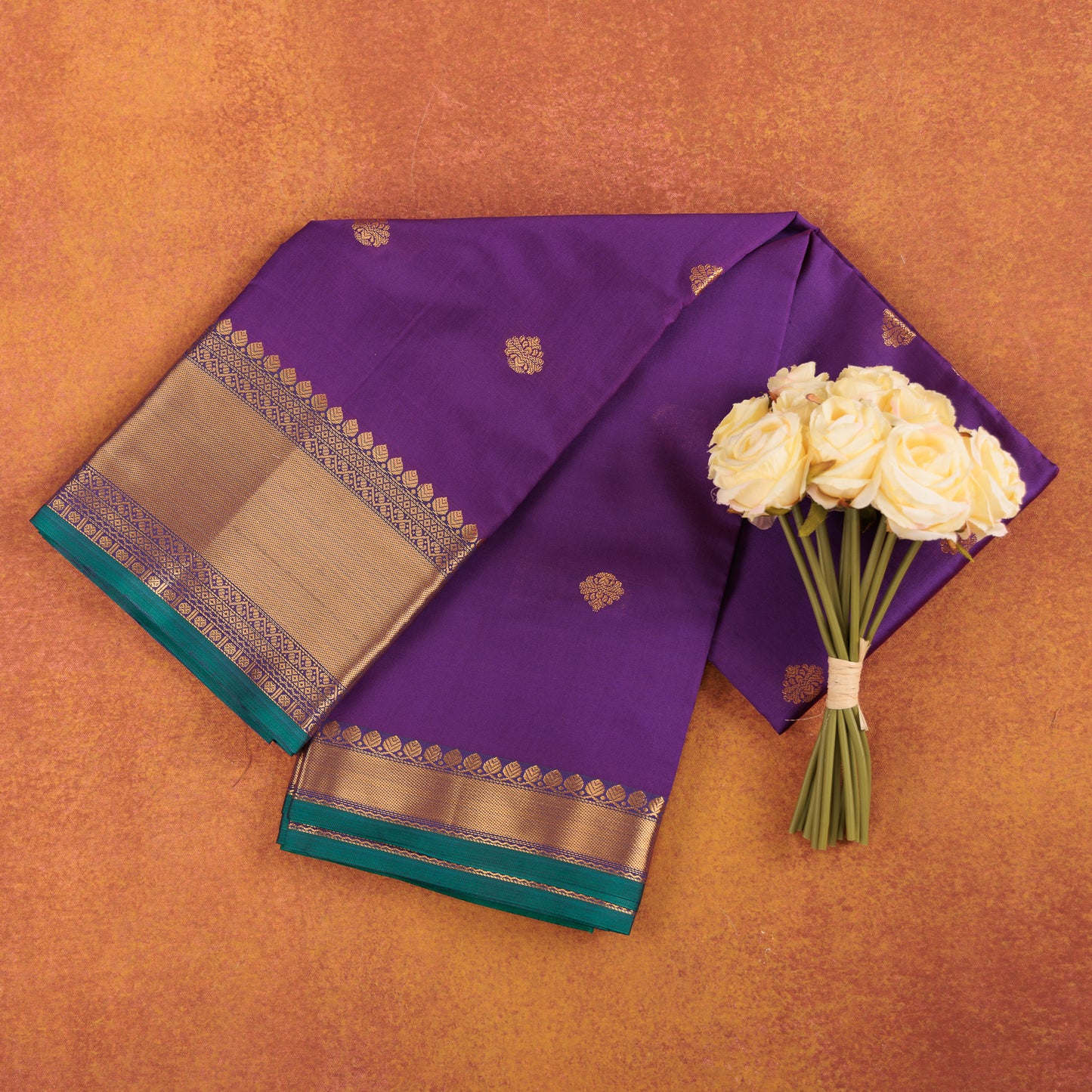 Royal-purple-kanjivaram-semi-silk-saree-with-gold-zari-butis-and-pink-border.