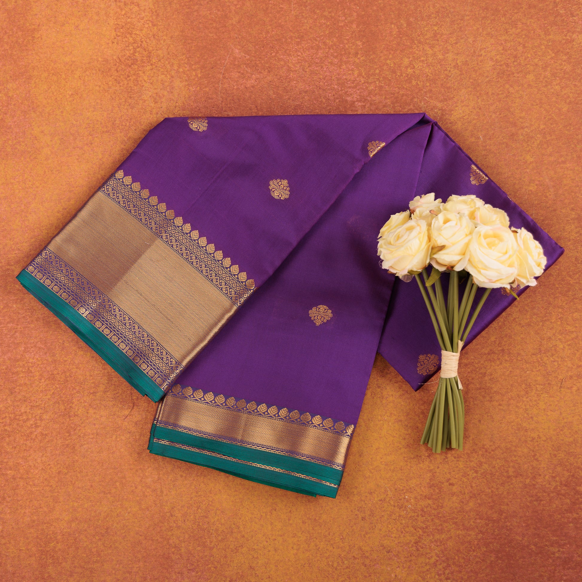 Royal-purple-kanjivaram-semi-silk-saree-with-gold-zari-butis-and-pink-border.
