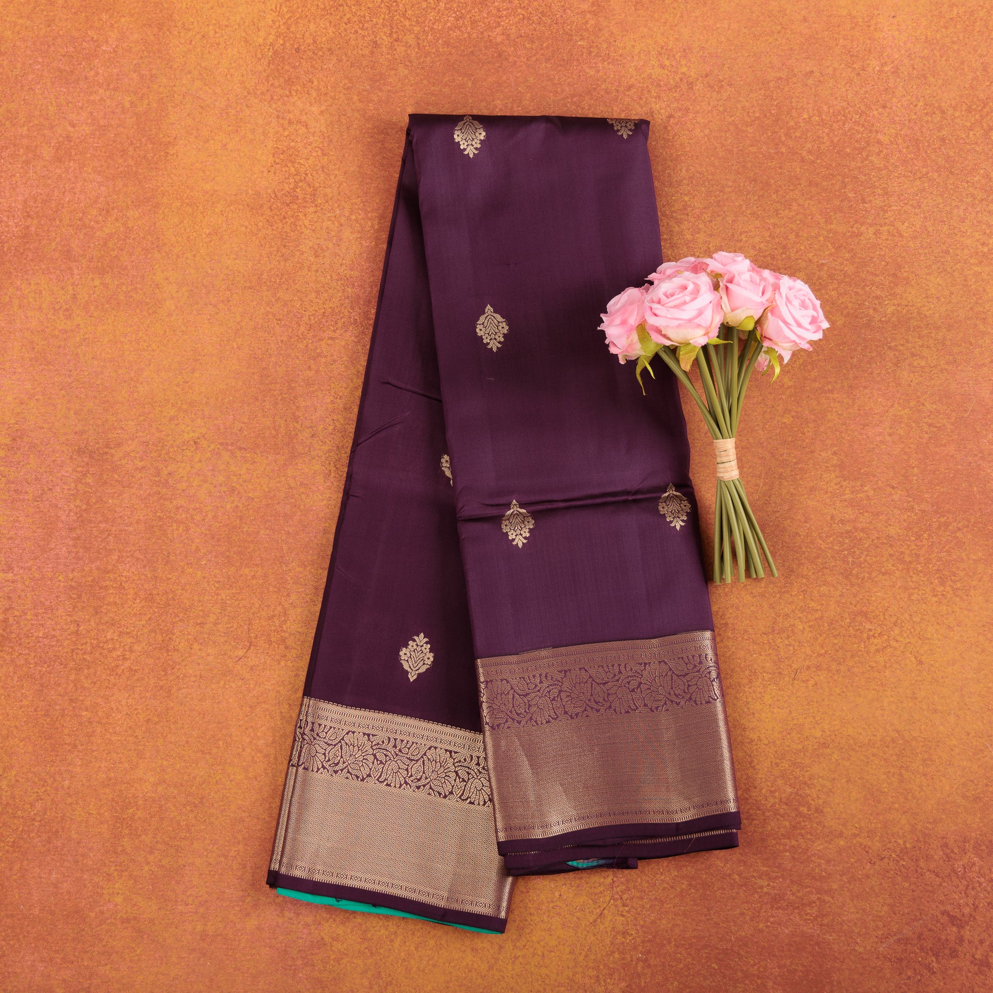 Deep-maroon-pure-kanjivaram-silk-saree-with-wide-gold-zari-border-and-roses.