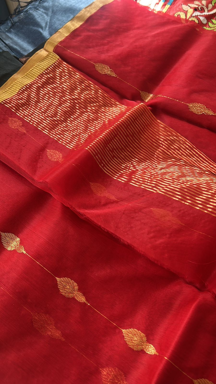 “Classic red Chanderi cotton silk saree with gold buti motifs and gold zari border, neatly draped and displayed.”
