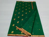 “Rich green Chanderi cotton silk saree with all-over gold buti motifs and gold zari border, neatly draped and displayed.”